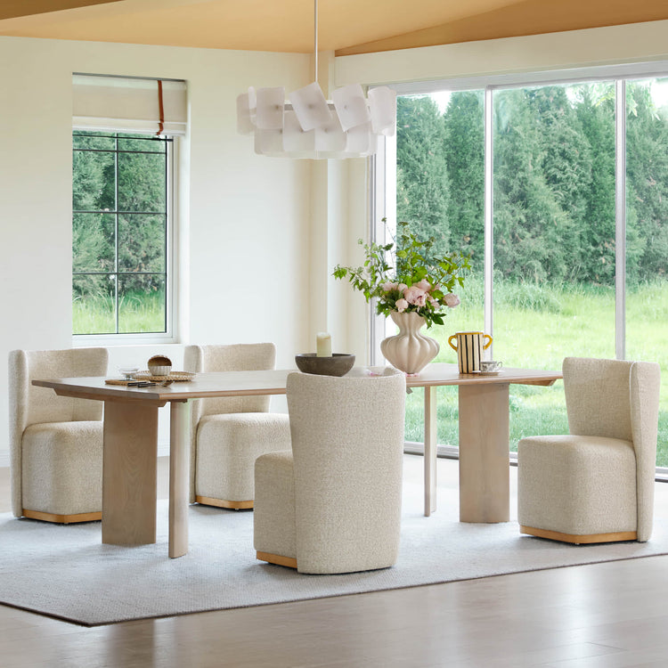 Cream textured wingback chairs at a light wooden dining table in a bright modern room - CHITA Living
