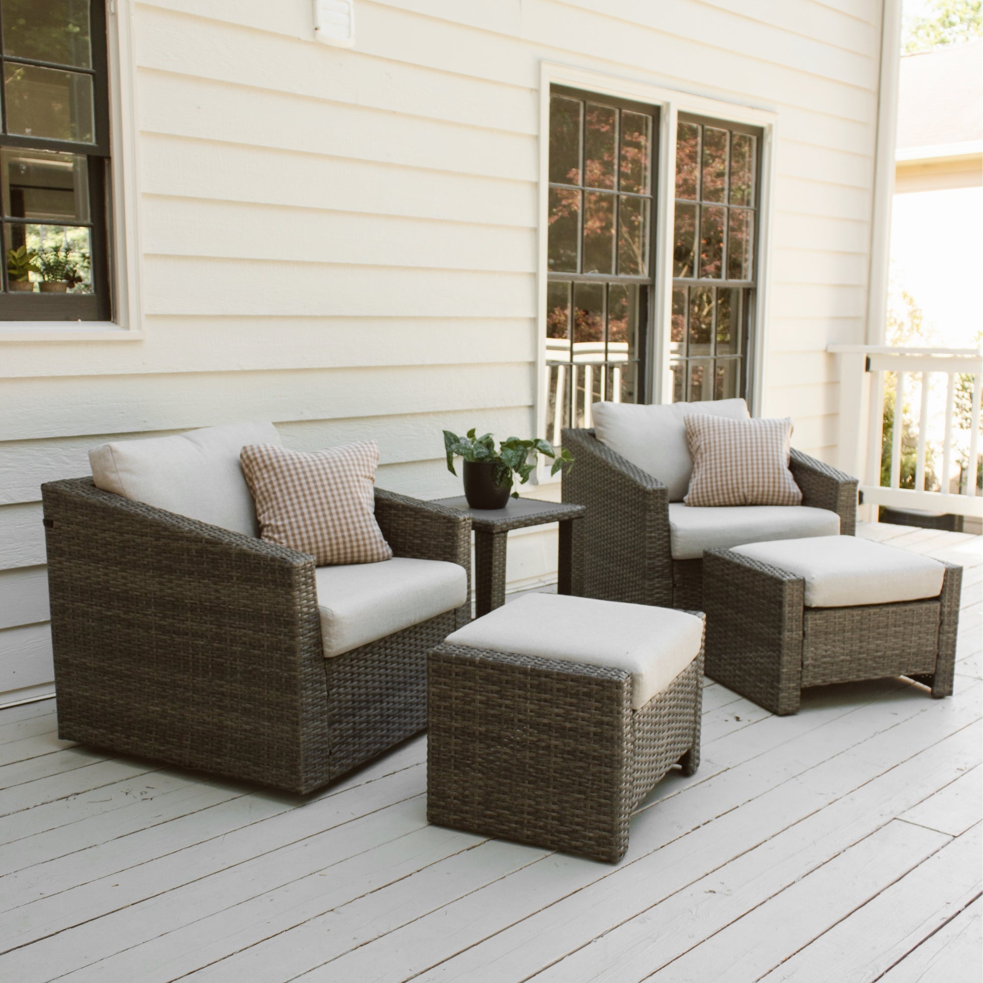 A cozy outdoor patio features wicker furniture with beige cushions