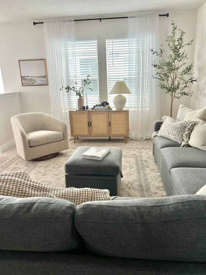 A cozy living room with a gray sectional sofa, a beige armchair
