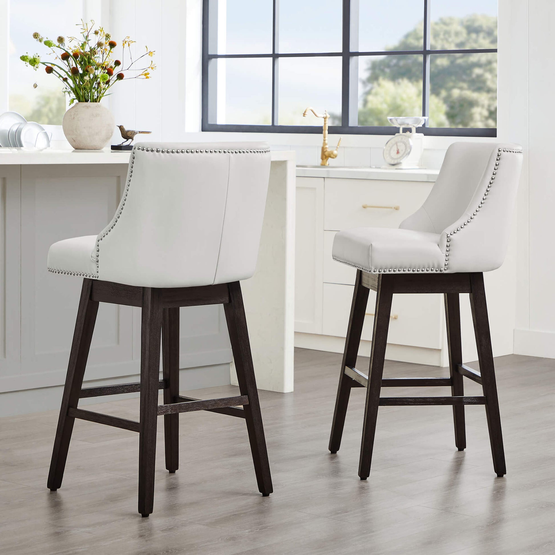 Asher swivel bar stools in white upholstery with nailhead trim in contemporary kitchen - CHITA Living