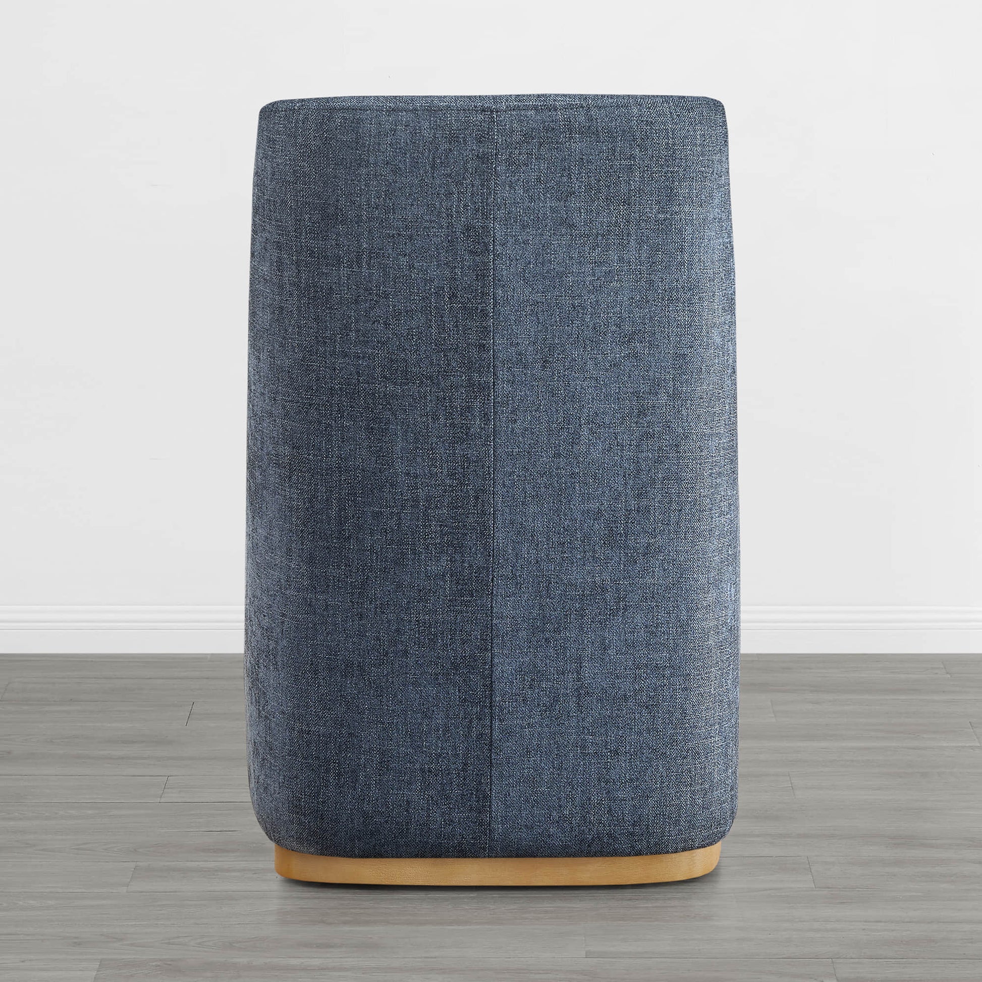 Back of blue wingback chair with curved wooden base in a minimalist room - CHITA Living