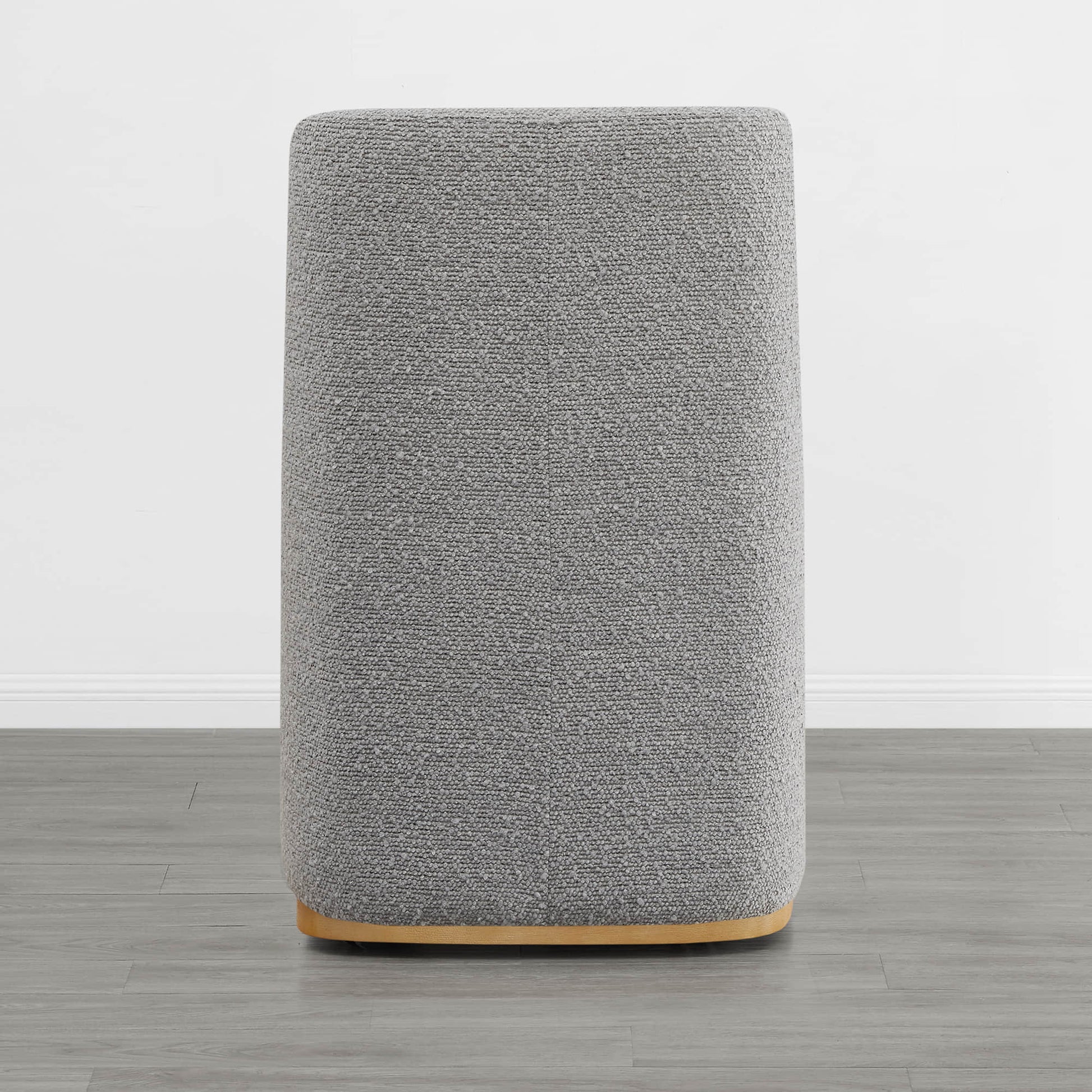 Back view of a gray upholstered dining chair with a wooden base in a minimalist interior - CHITA Living