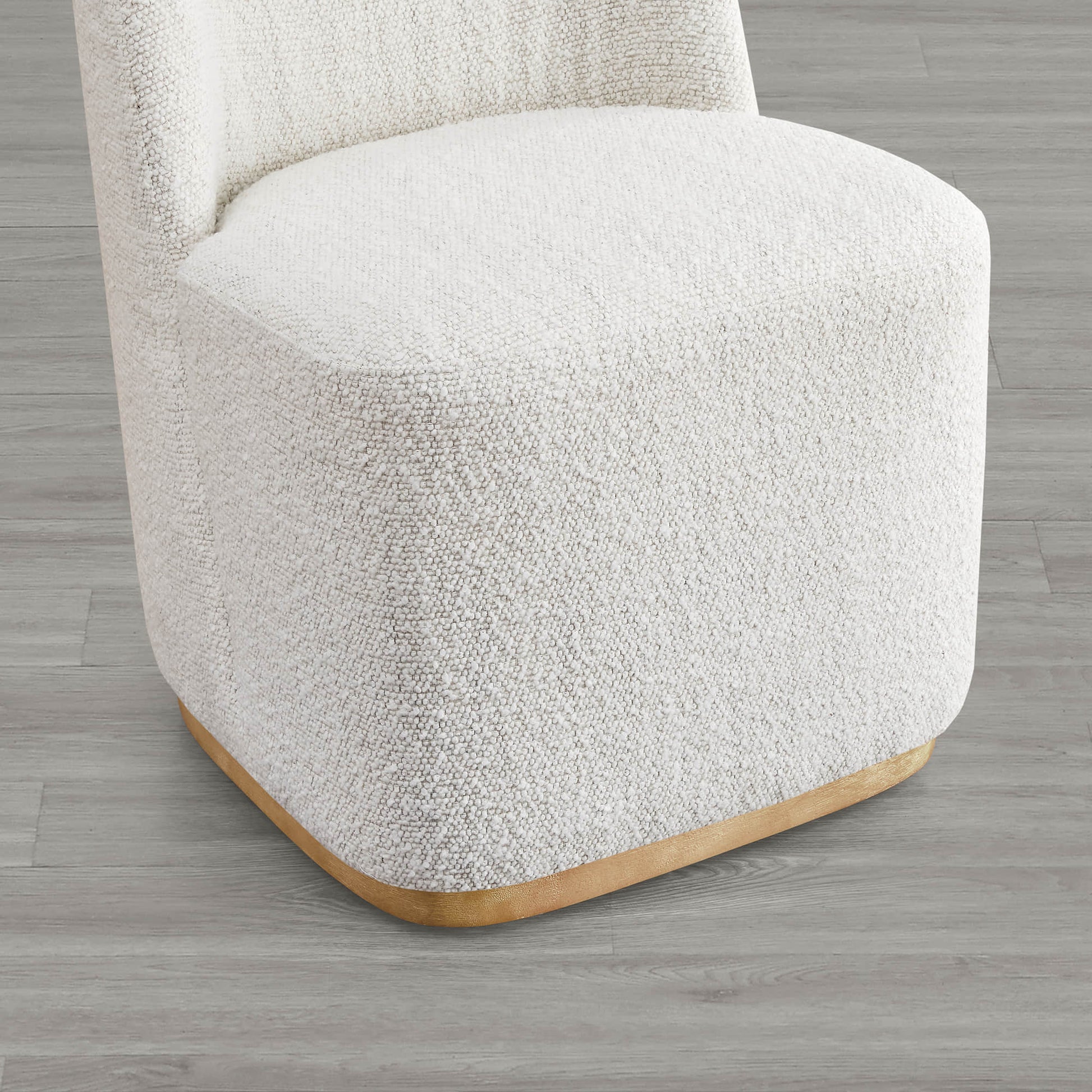 Close-up of cream boucle upholstered dining chair base with curved wooden accent - CHITA Living