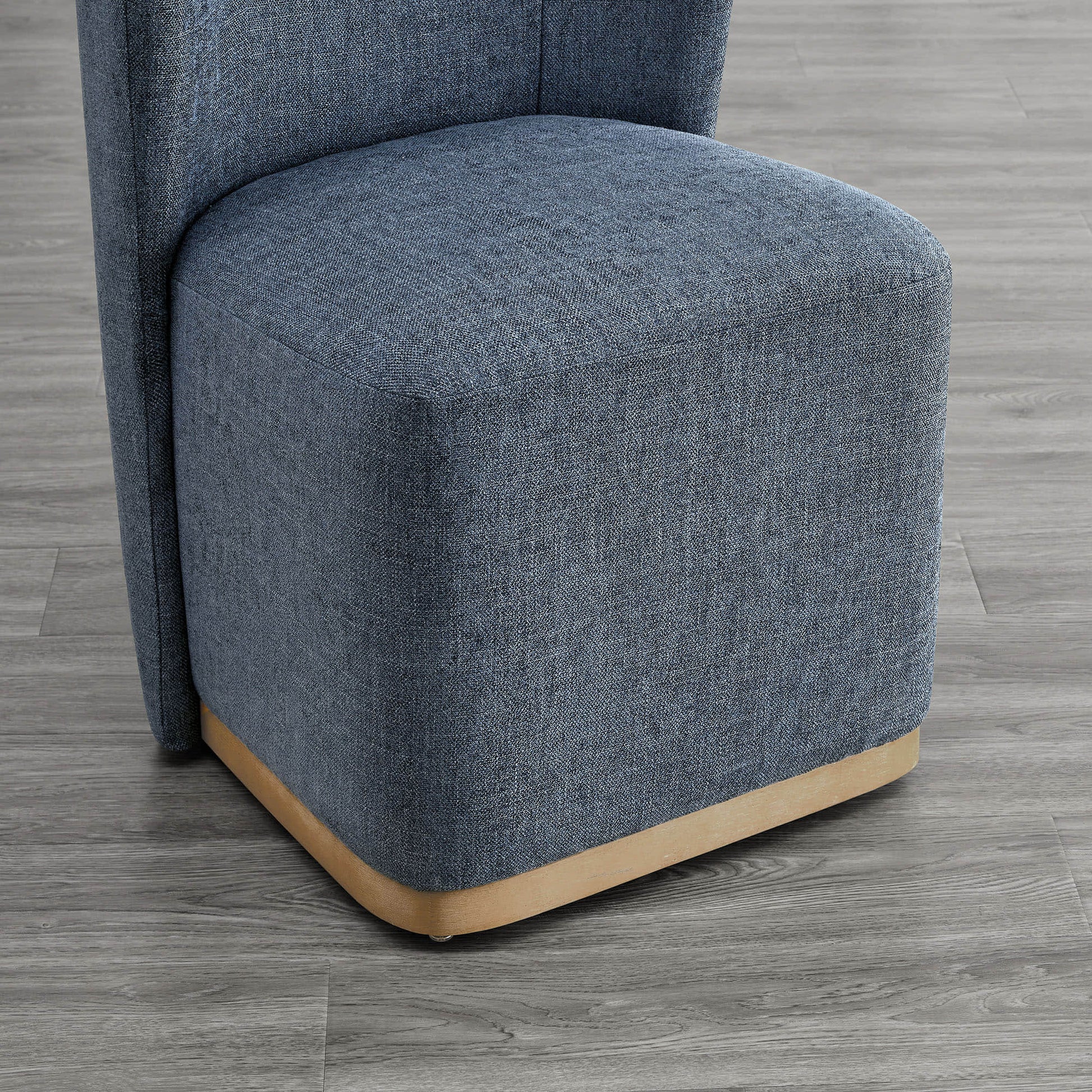 Close-up of blue dining chair with curved wood base and textured upholstery - CHITA Living