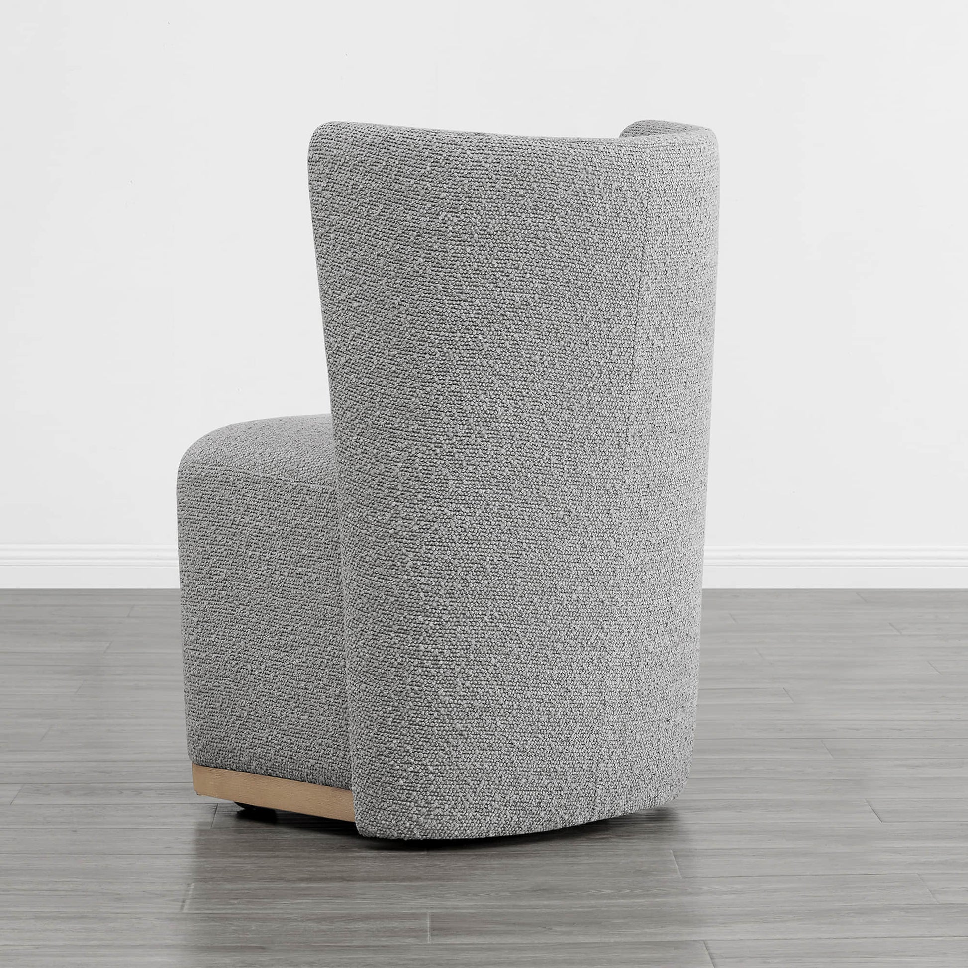 Gray upholstered wingback chair with curved design and wooden base in minimalist room - CHITA Living