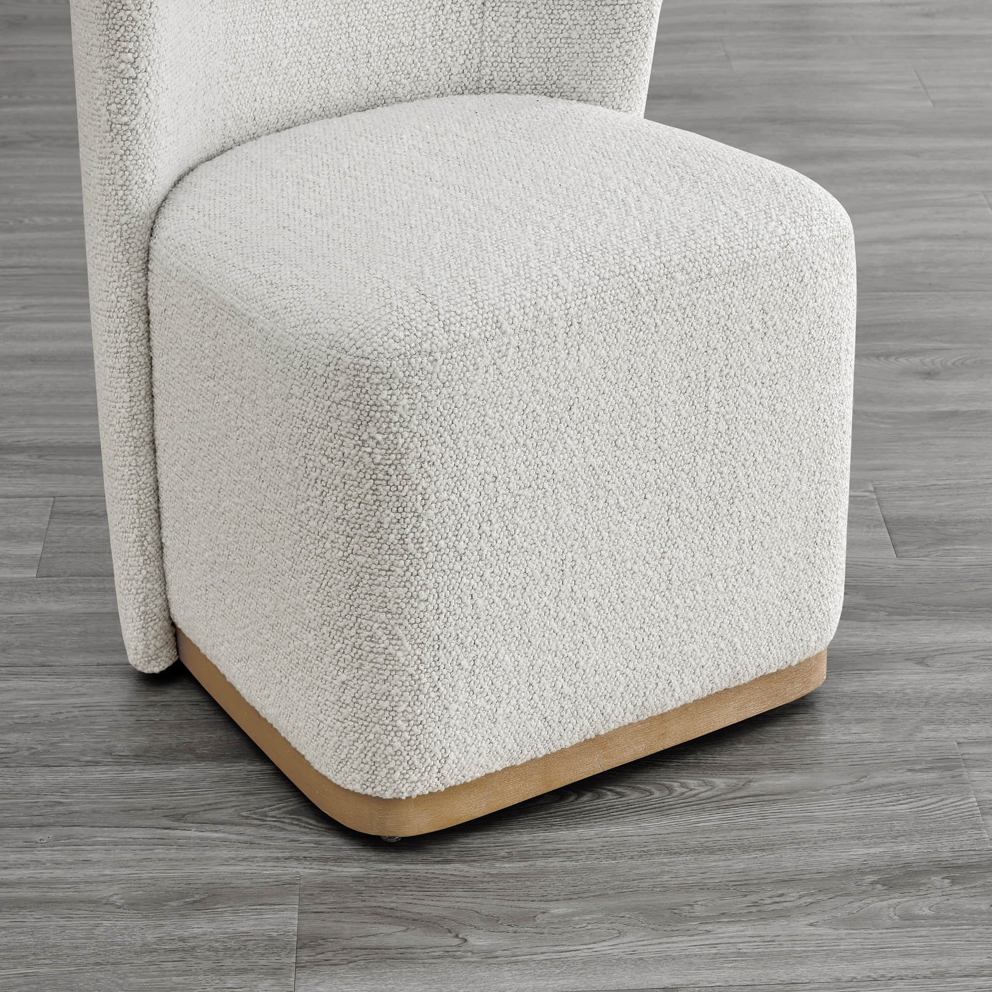 Close-up of textured cream dining chair base with curved wooden detail - CHITA Living