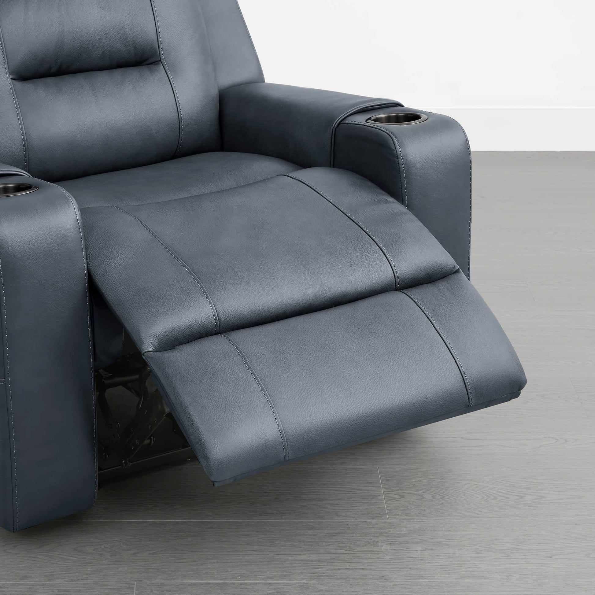 A dark blue leather recliner with an extended footrest and cup holders in the armrests.