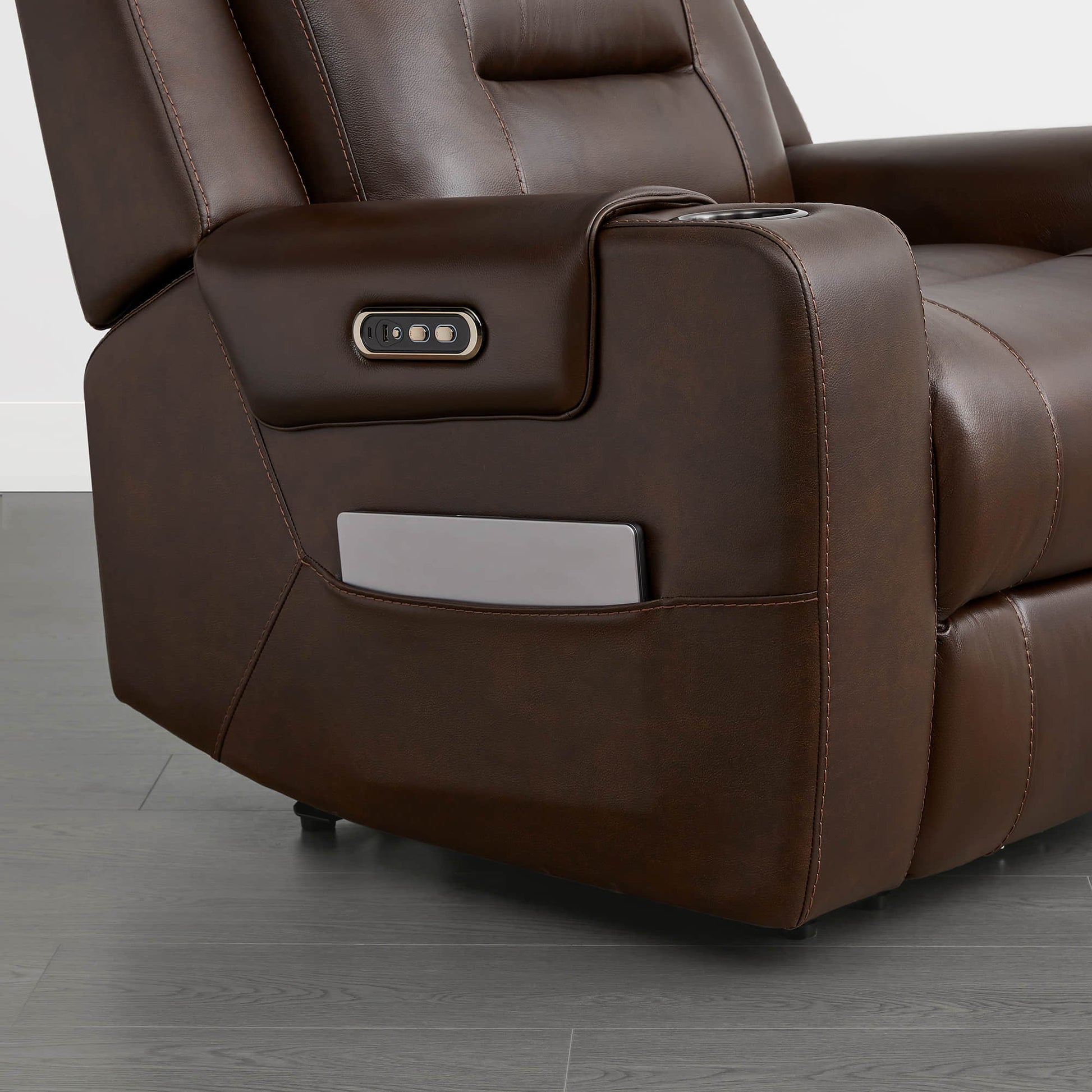 A dark brown leather recliner armrest with a control panel and a storage compartment.
