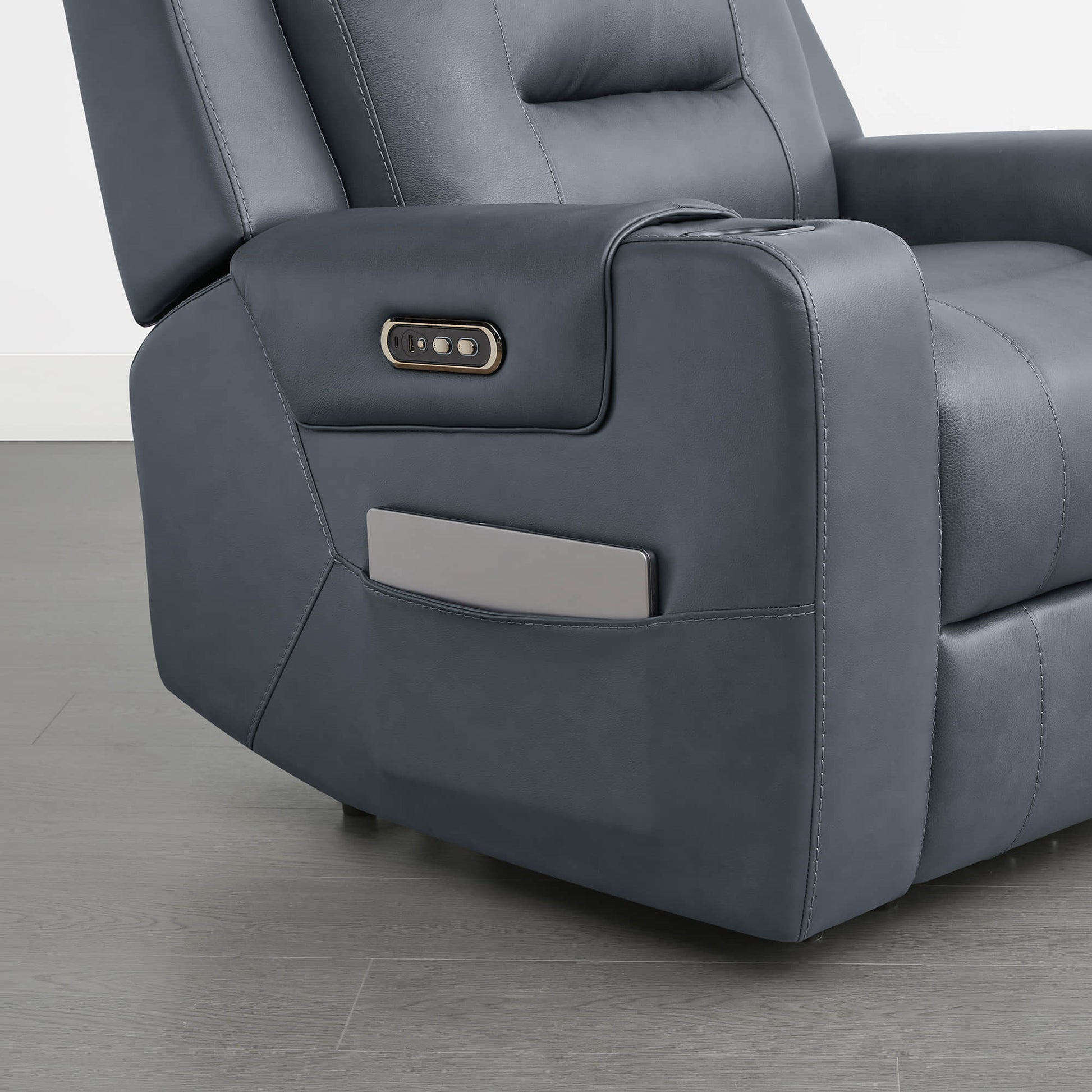 
A dark blue leather recliner armrest with a control panel and a storage compartment.