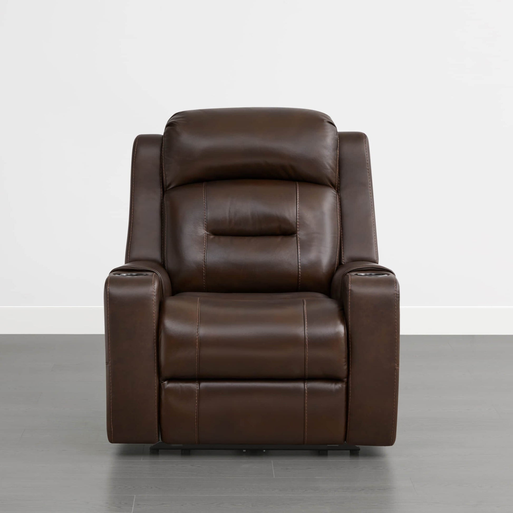 A dark brown leather recliner with cup holders in the armrests, set against a plain background.