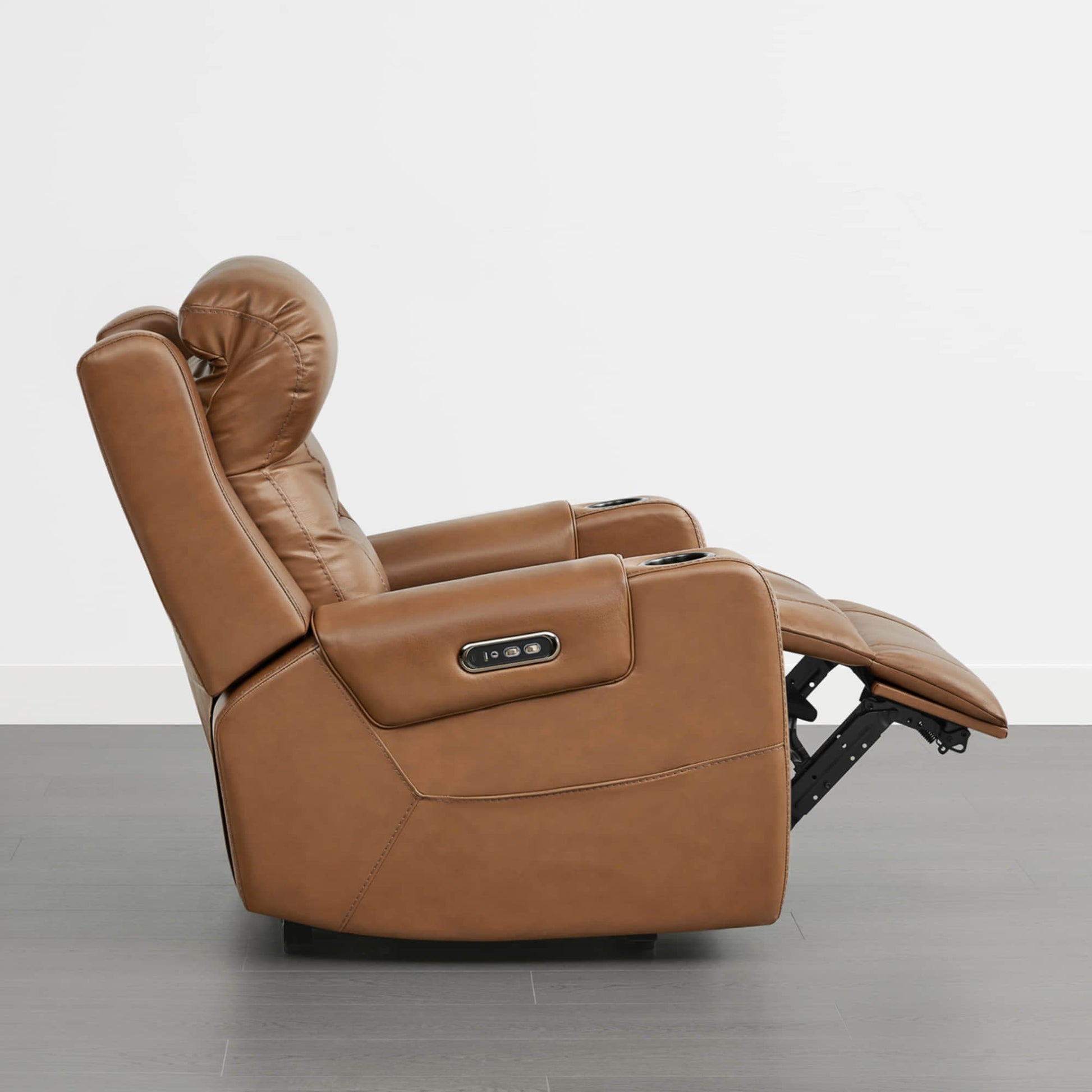 A tan leather recliner with a power headrest, cup holders, and control panel on the armrest.