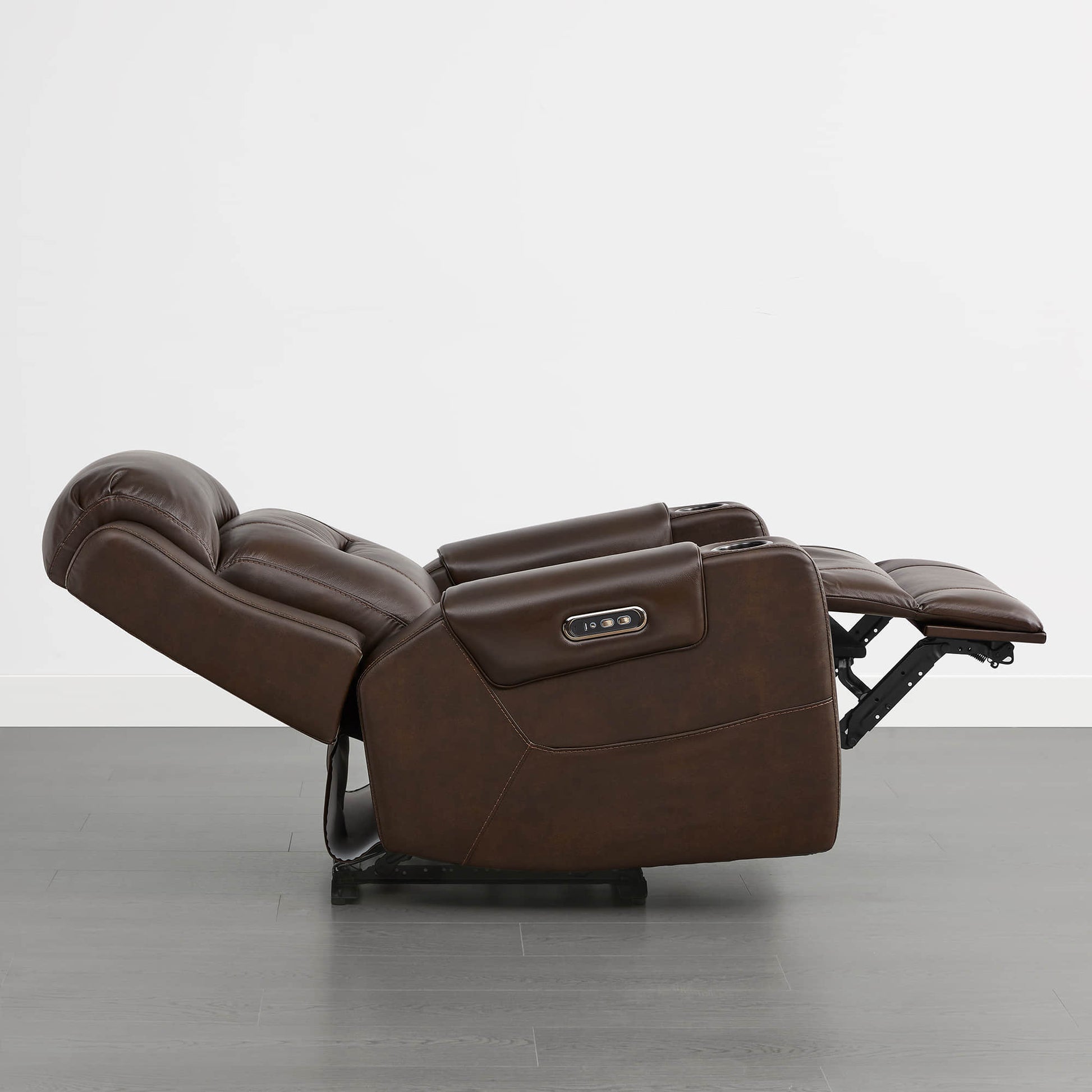 A dark brown leather recliner in the fully reclined position with a control panel on the armrest.