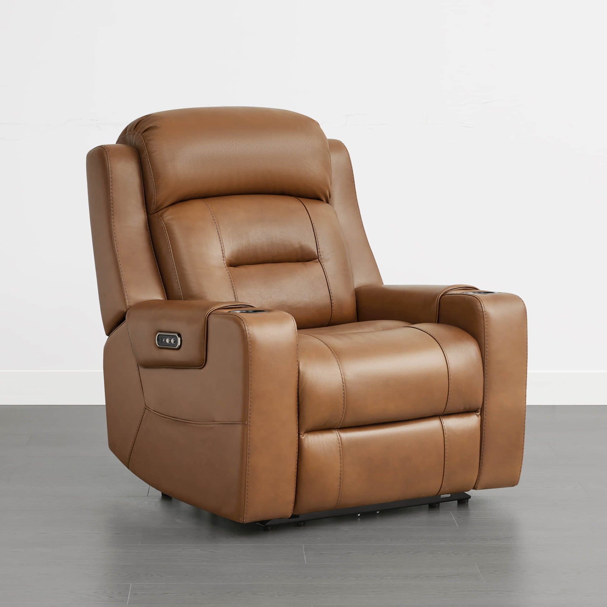 A tan leather recliner with a partially extended footrest and control panel on the armrest.