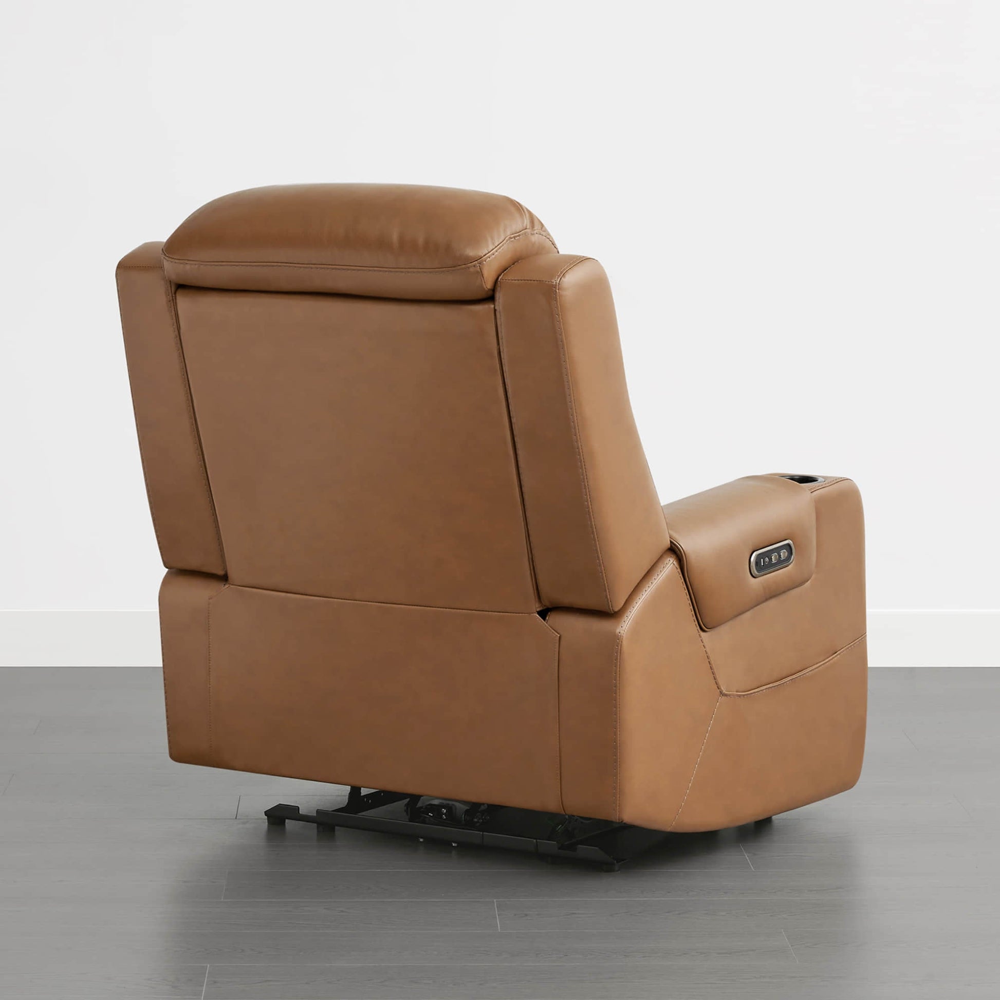 A tan leather recliner with a control panel on the armrest, viewed from the back.