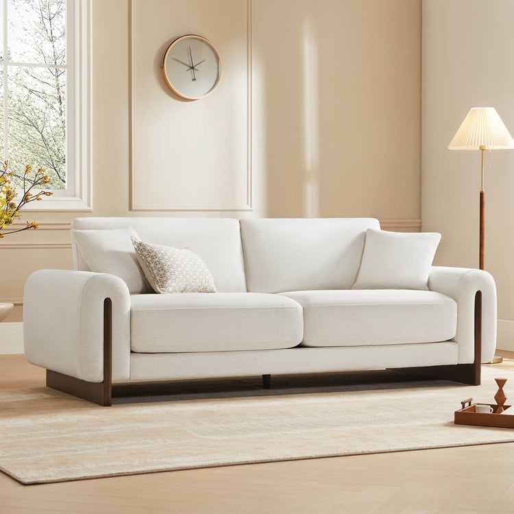 Elegant white lounge sofa with cushions in a living room setting.
