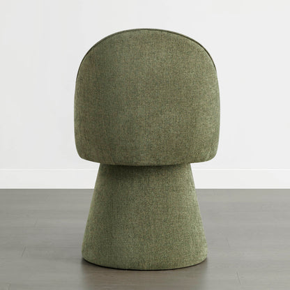 A green swivel chair viewed from the back, placed on a wooden floor against a white wall.