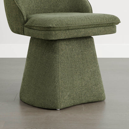 A close-up of a green swivel chair showing the cushioned seat and base, placed on a wooden floor against a white wall.