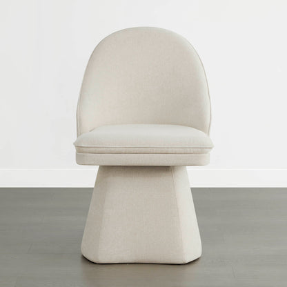 A single cream-colored swivel chair with a modern design, featuring a rounded backrest and a cushioned seat, placed on a wooden floor against a plain white wal