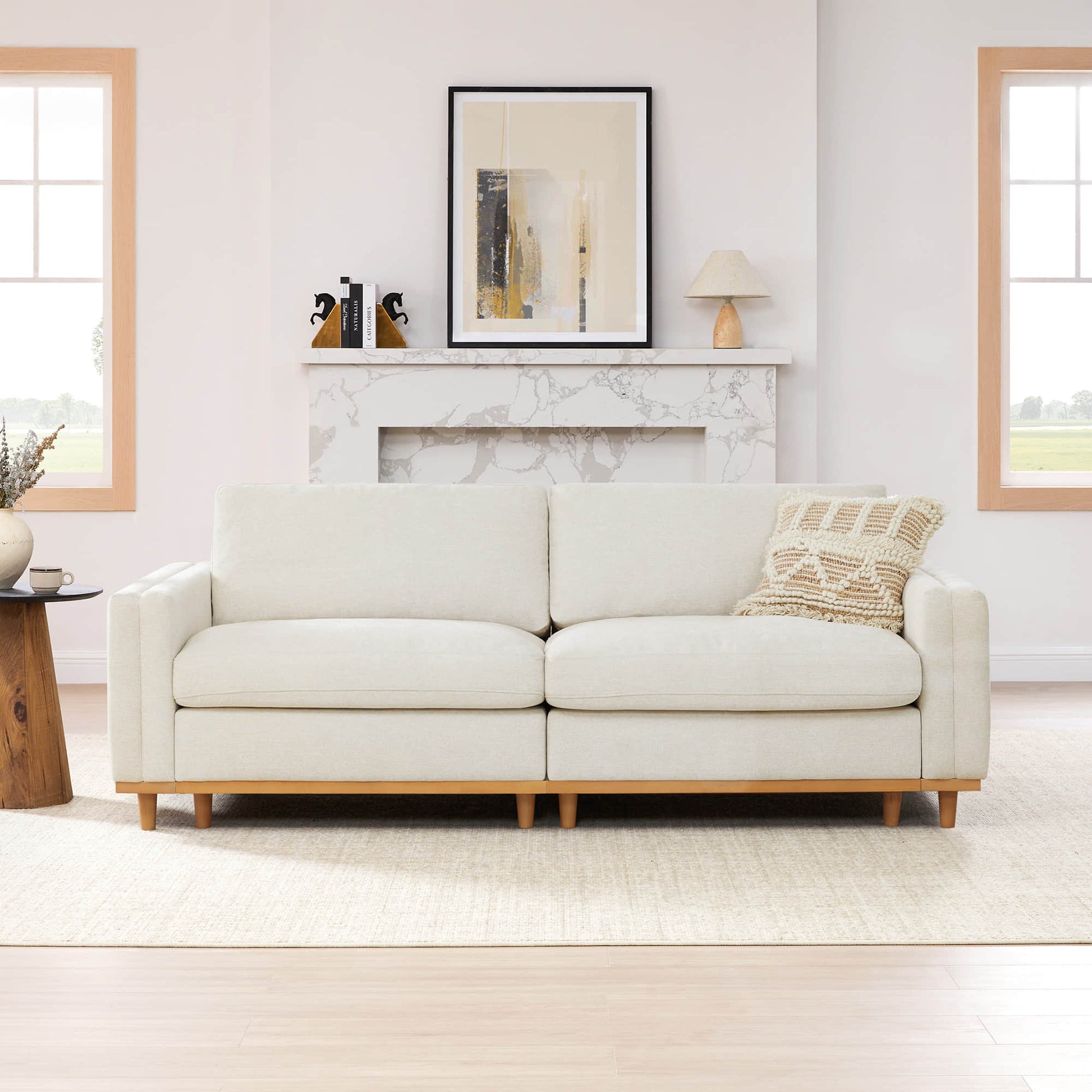 Cream modular sofa with wooden legs and decorative pillow in bright living room - CHITA Living