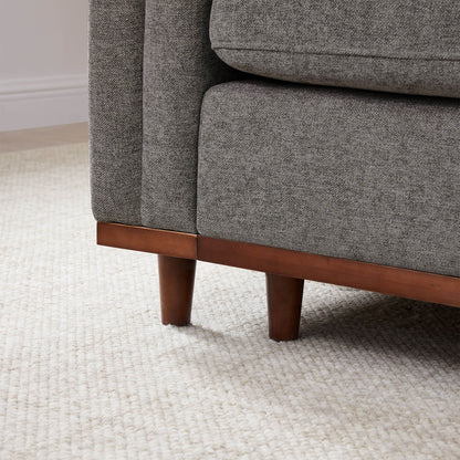 Close-up of Liam Sectional Sofa leg in dark wood with textured gray upholstery - CHITA Living