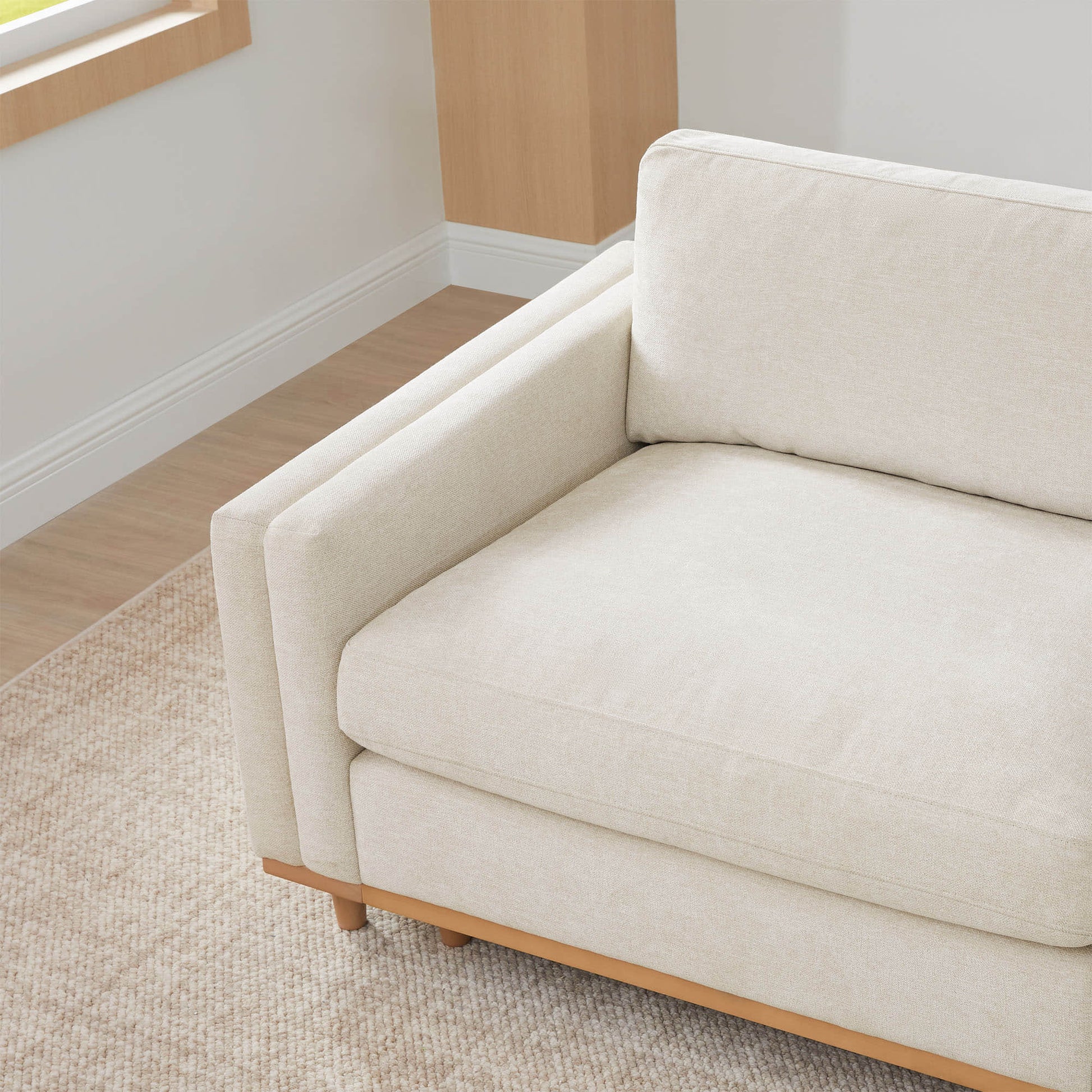 Liam Modular Sofa close-up with beige cushions and wood base in bright room - CHITA Living