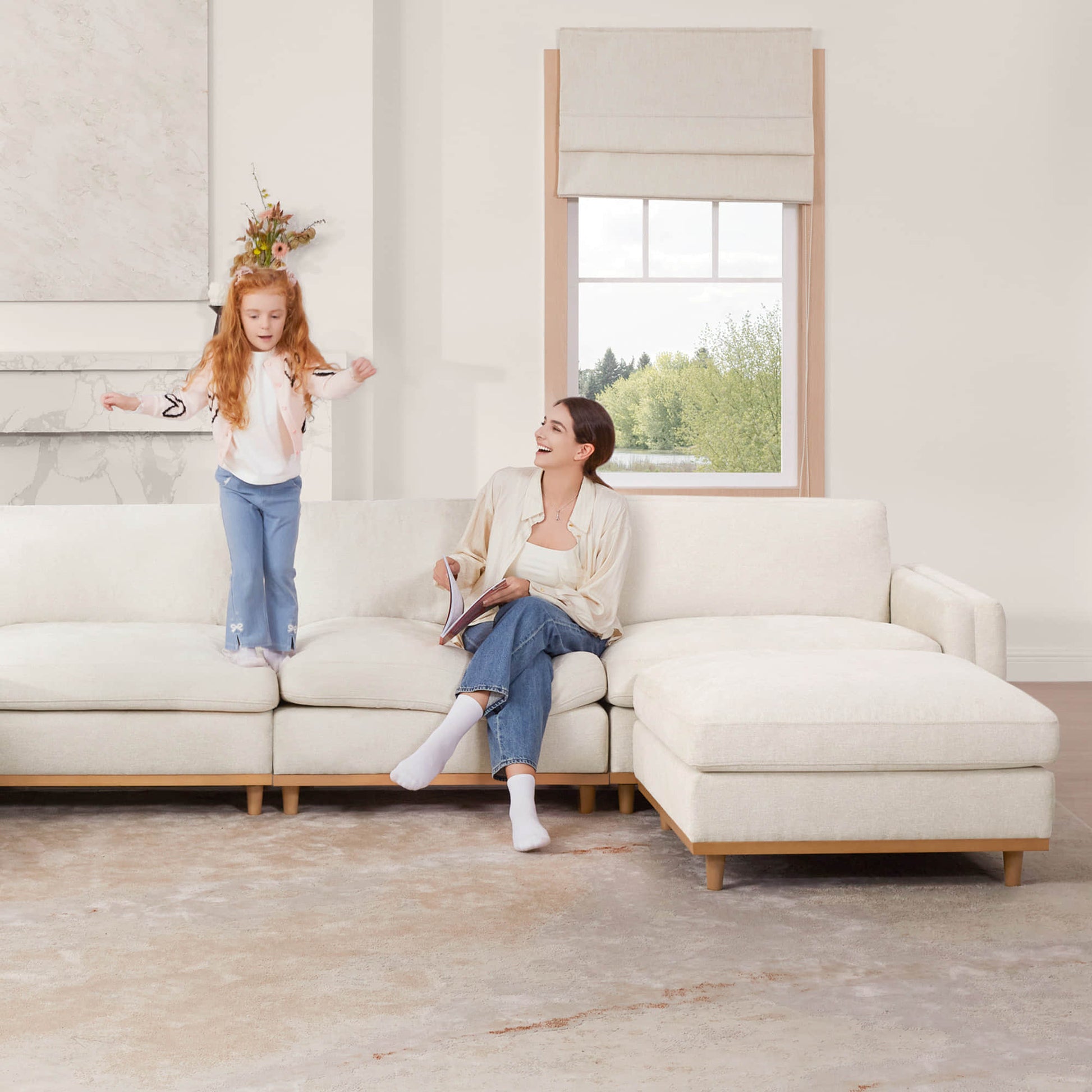 Woman and girl having fun on Liam overstuffed sectional sofa in modern bright living room - CHITA Living