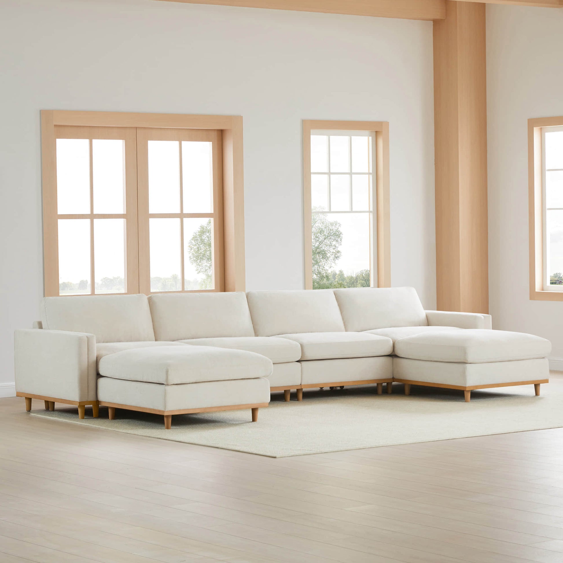 Liam modular sectional sofa in light fabric with wooden legs in a modern living space - CHITA Living