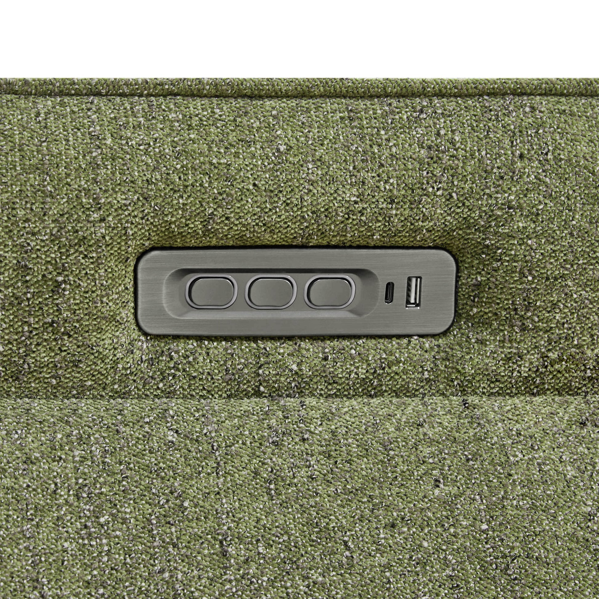 Close-up of power recliner control panel embedded in the green upholstered chair.