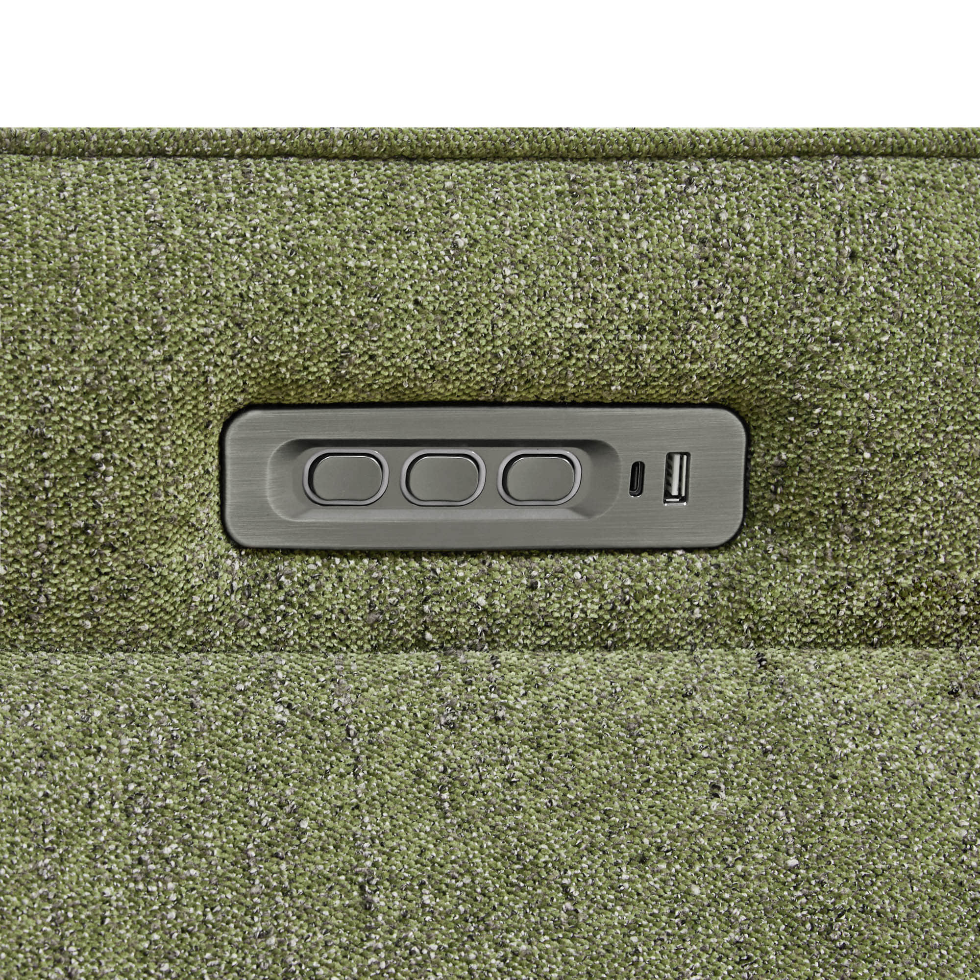 Close-up of power recliner control panel embedded in the green upholstered chair.