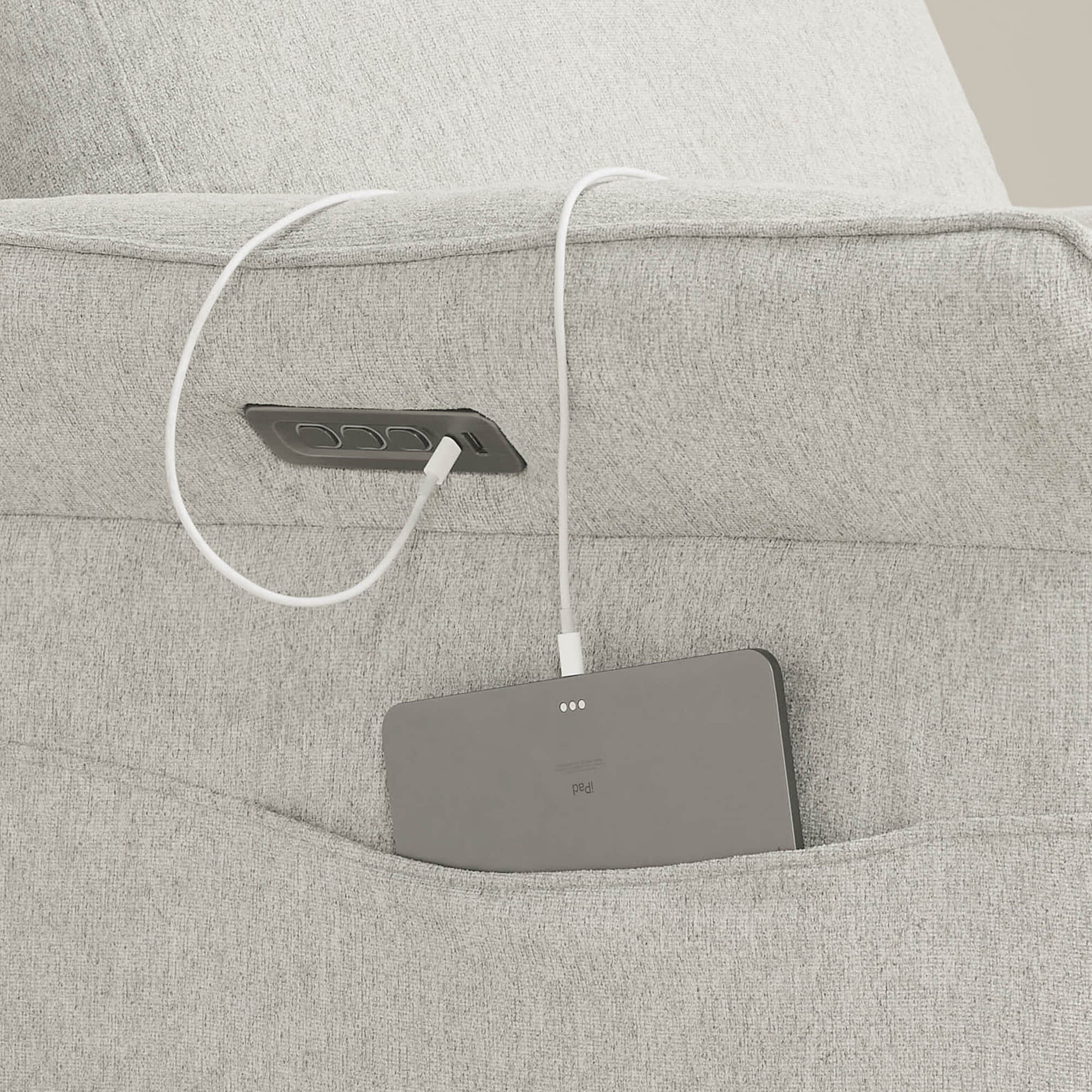 Gray power recliner footrest control panel cleverly integrated into armrest design.