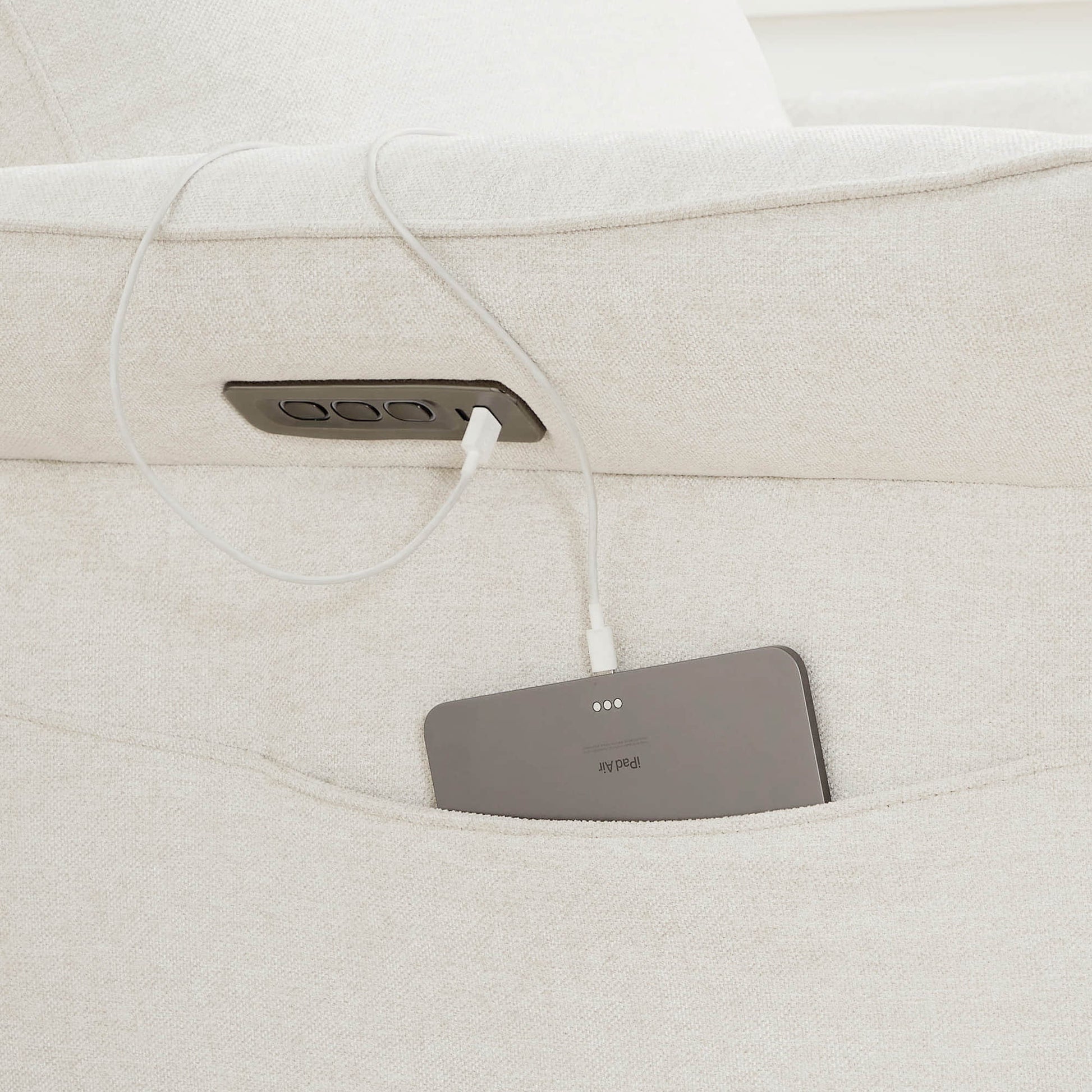 Gray power recliner footrest detail showing textured upholstery and padding.