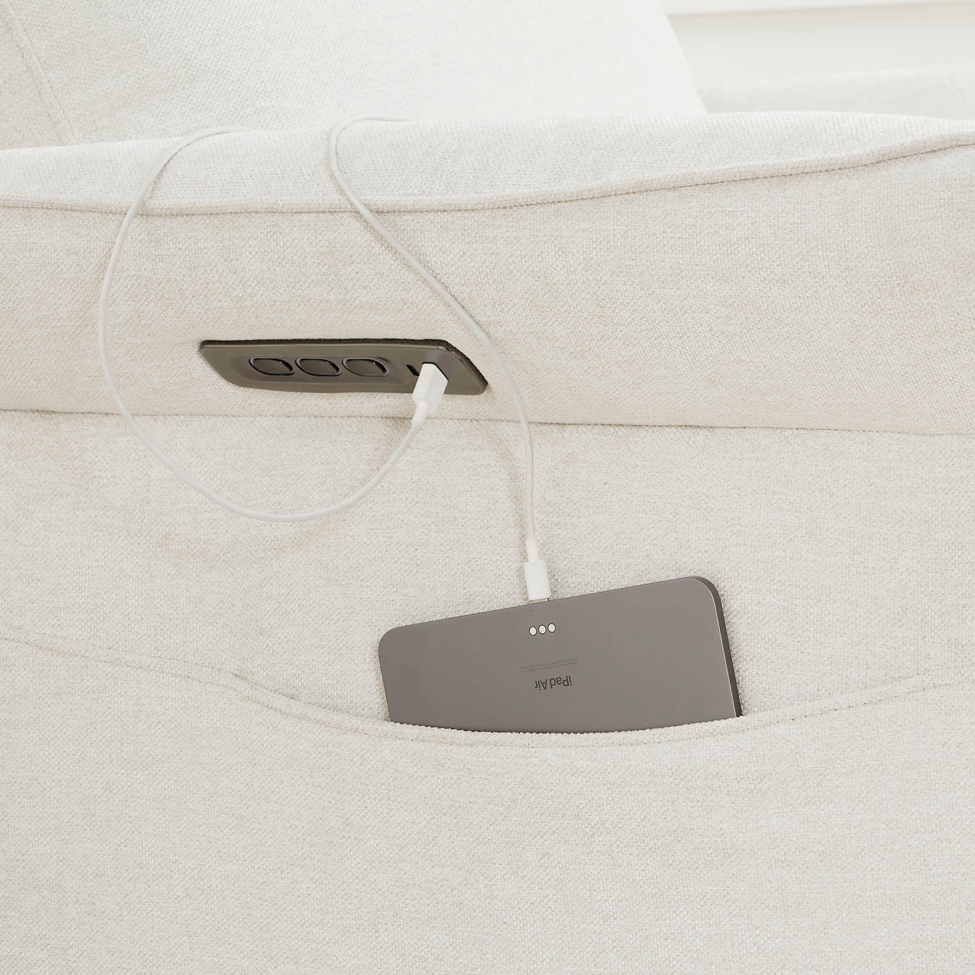 Gray power recliner footrest detail showing textured upholstery and padding.