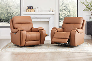Two brown leather recliners in a bright room with a fireplace and large windows.