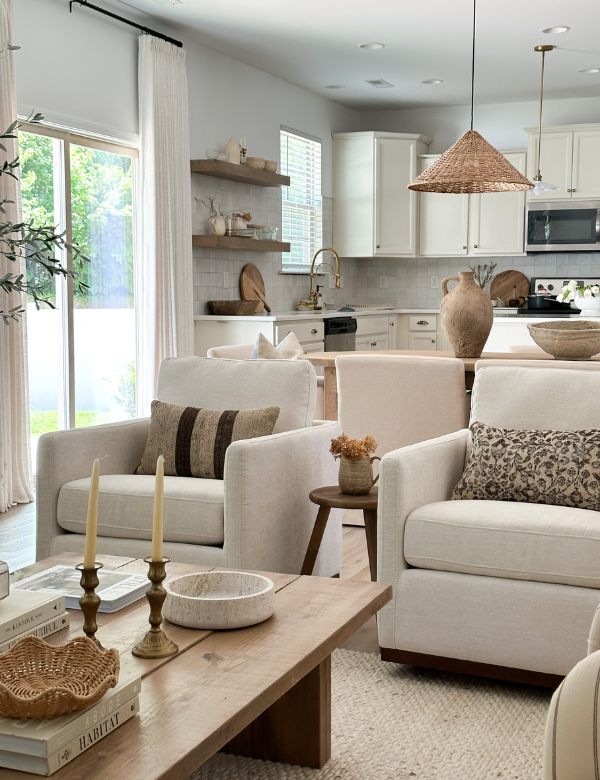 A cozy living area with cream armchairs, a wooden coffee table