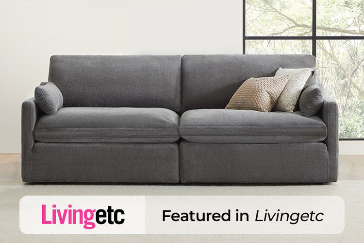 A gray, plush sofa with cushions, featured in Livingetc magazine.