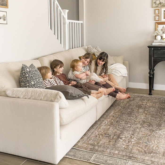 Four children are sitting on a white sofa