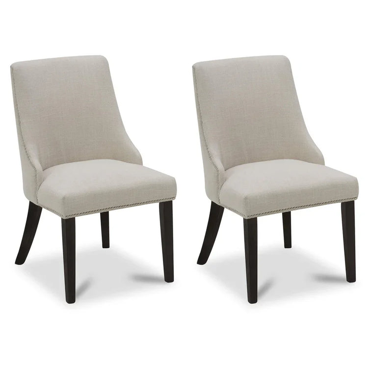 Two beige upholstered dining chairs with dark wooden legs and nailhead trim
